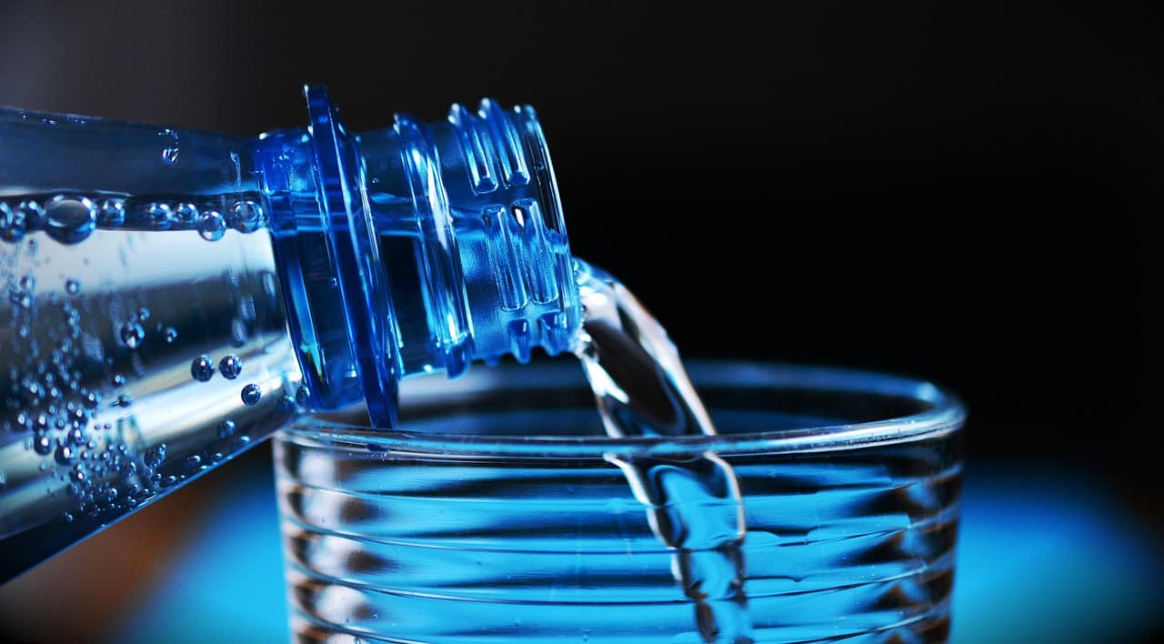 Trinkwasserhygiene: Fachmann überprüft Durchflussmenge an einer Armatur